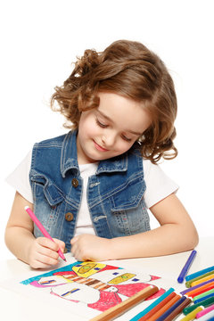 Cheerful little girl with sketch pen drawing in kindergarten
