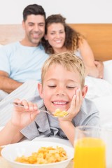 Obraz na płótnie Canvas Cute young family having breakfast in bed