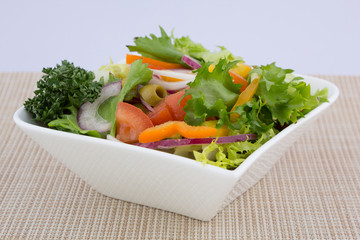 Bowl of healthy green garden salad with fresh vegetables