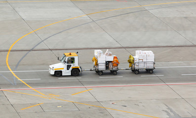 tug and luggage on the airport tarmac