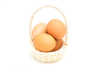 brown eggs in basket on a white background