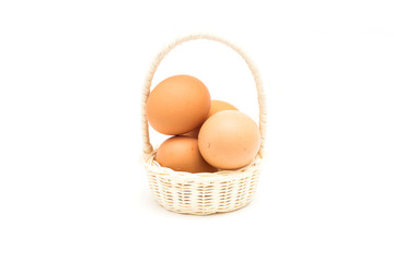 Brown eggs in the basket on white.