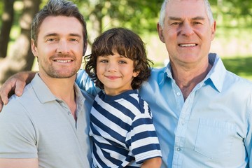 Grandfather father and son smiling at park