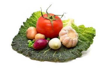 Garlic, onion, peas, tomatoes on a cabbage leaf