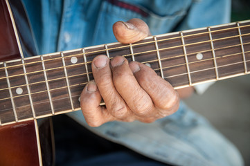 Fototapeta na wymiar hands of the old man hold guitar