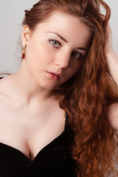 Portrait of young female touching her red hairs