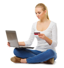 Naklejka premium Young girl in jeans with laptop and credit card