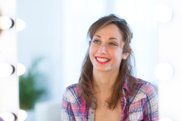 cheerful young women making herself up