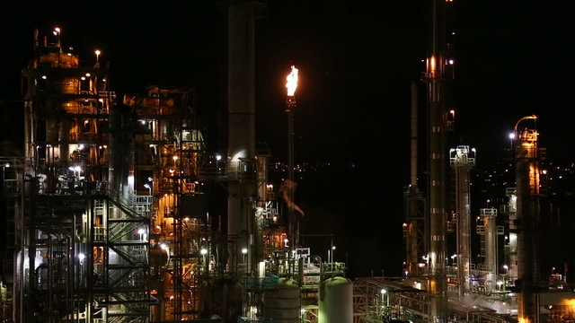 Oil Refinery at Night with Flame