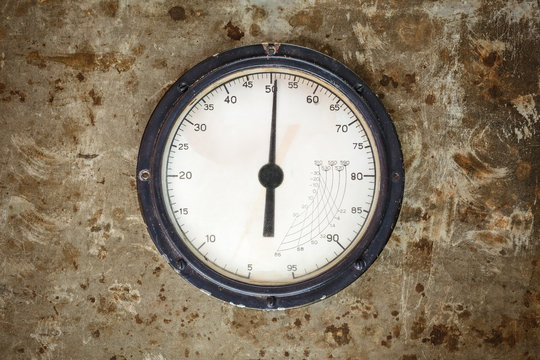 Vintage industrial meter on a metal background