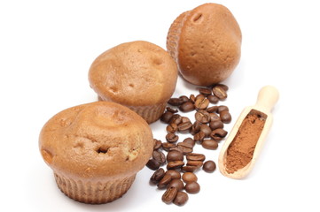 Fresh baked muffins, coffee grains and powdery cinnamon