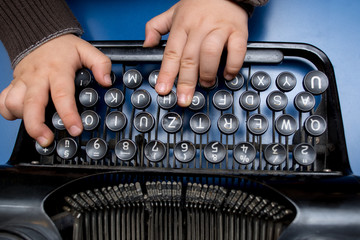 Child playing with old typewriter