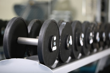 Lot of dumbbells in gym close-up