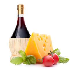 Red wine bottle, cheese and tomato still life