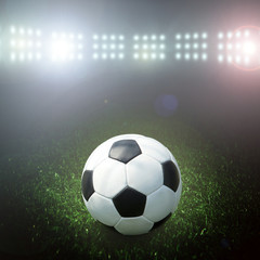 Naklejka premium Soccer ball on the field of stadium with light