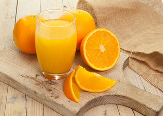 naranjas cortadas con vaso sobre madera