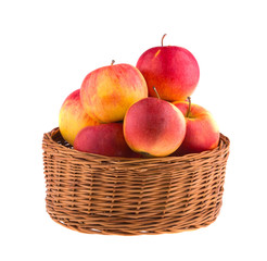 Apples in a wooden basket isolated on white background.