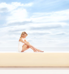 Fototapeta na wymiar Young attractive woman getting spa treatment on a sky background