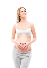 A young blond pregnant woman in white sporty clothes