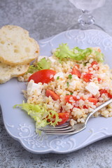 salad with tomatoes, feta cheese, grits and green