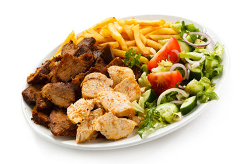Grilled meat with French fries and vegetables