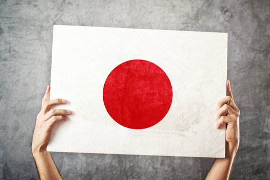 Japan flag. Man holding banner with Japanese Flag.