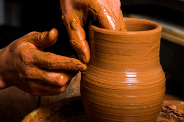 hands of a potter, creating an earthen jar