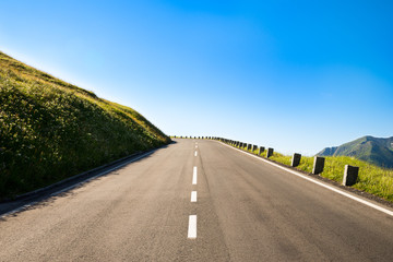 Obraz premium empty country road with a sharp left curve in the brow of a hill
