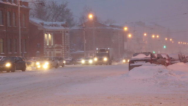cars on a city street in a blizzard at dawn