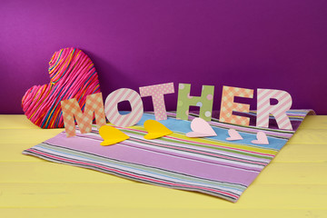 Mother- lettering of handmade paper letters on purple
