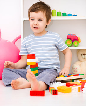 Boy is playing with building blocks