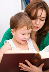 Mother is reading book with her son