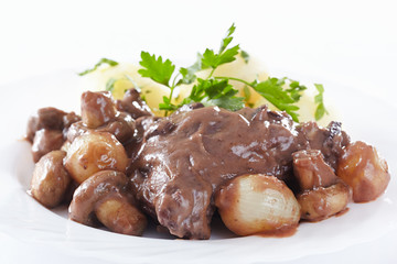 Chicken in red wine with onions, mushrooms and bacon