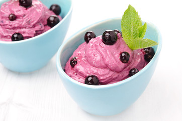 blackcurrant mousse with cream cheese in blue bowls, horizontal