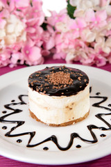 Sweet cake with chocolate on plate on table close-up
