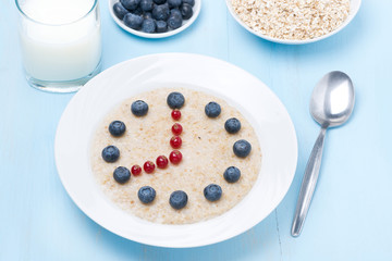 Obraz na płótnie Canvas oatmeal with berries in the form of dial