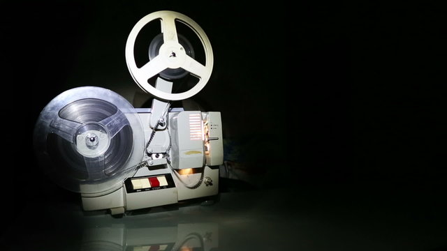 old projector showing film on screen - dolly shot