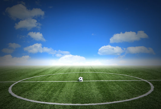 Soccer green grass field with blue sky white clouds background
