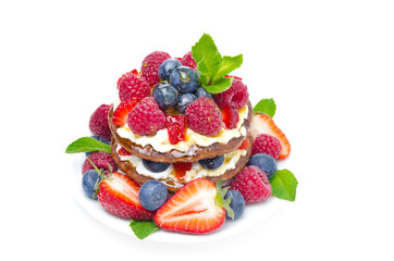 Pancake cake with whipped cream and fresh berries, isolated