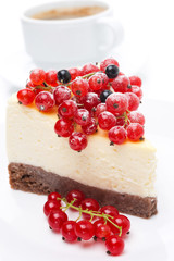 piece of cheesecake with red and black currants, cup of coffee