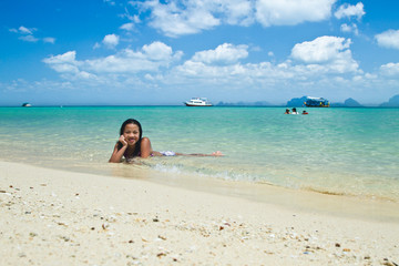 Fototapeta na wymiar Girl lying in the water at the beach of the Koh Ngai island Thai