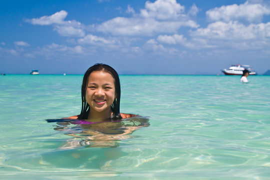 Girl swimming in the water at the beach of the Koh Ngai island T