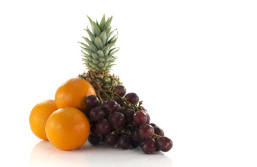 Fototapeta na wymiar red grapes oranges and pineapple