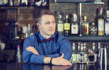 young man working as a bartender in a nightclub bar