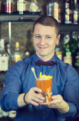 young man working as a bartender in a nightclub bar