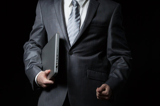 businessman holds laptop
