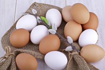 Brown and white fresh eggs on a light background