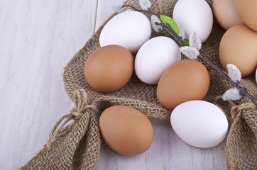 Brown and white fresh eggs on a light background