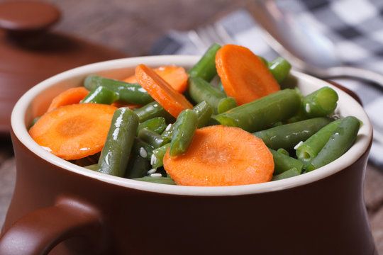 Green beans with sliced ​​carrots in a pot for baking