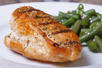 Grilled chicken steak on white plate with green beans